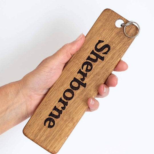 Extra Large, it's huge, wooden Oak keyring in a personals hand